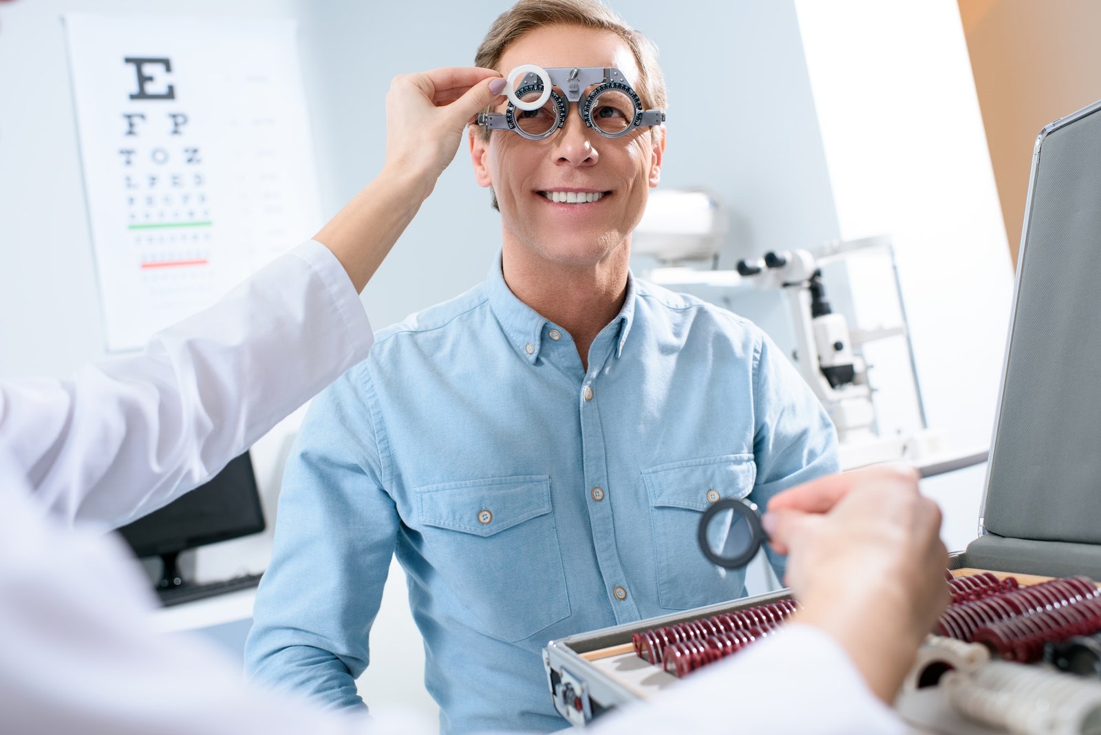 Ophthalmologist Examining Middle Aged Man Eyes With Trial Frame And Lenses