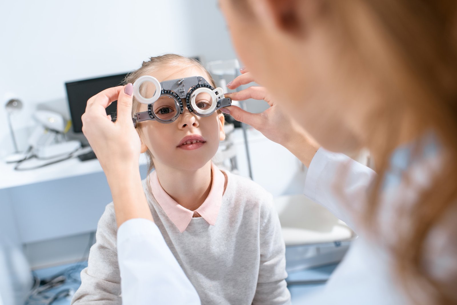Selective Focus Of Ophthalmologist Examining Kid Eyes With Trial Frame In Clinic